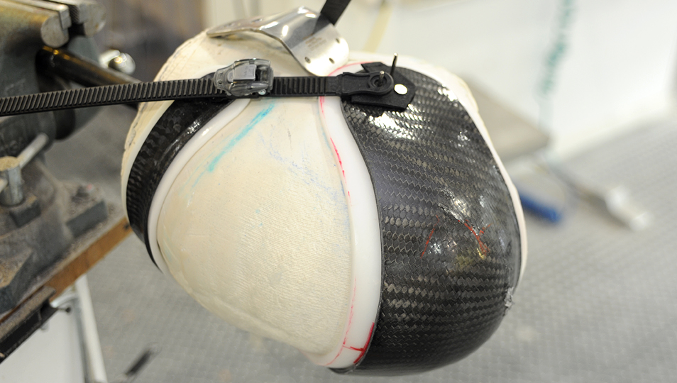 A custom carbon fiber frame being crafted around a hand-cast mold.