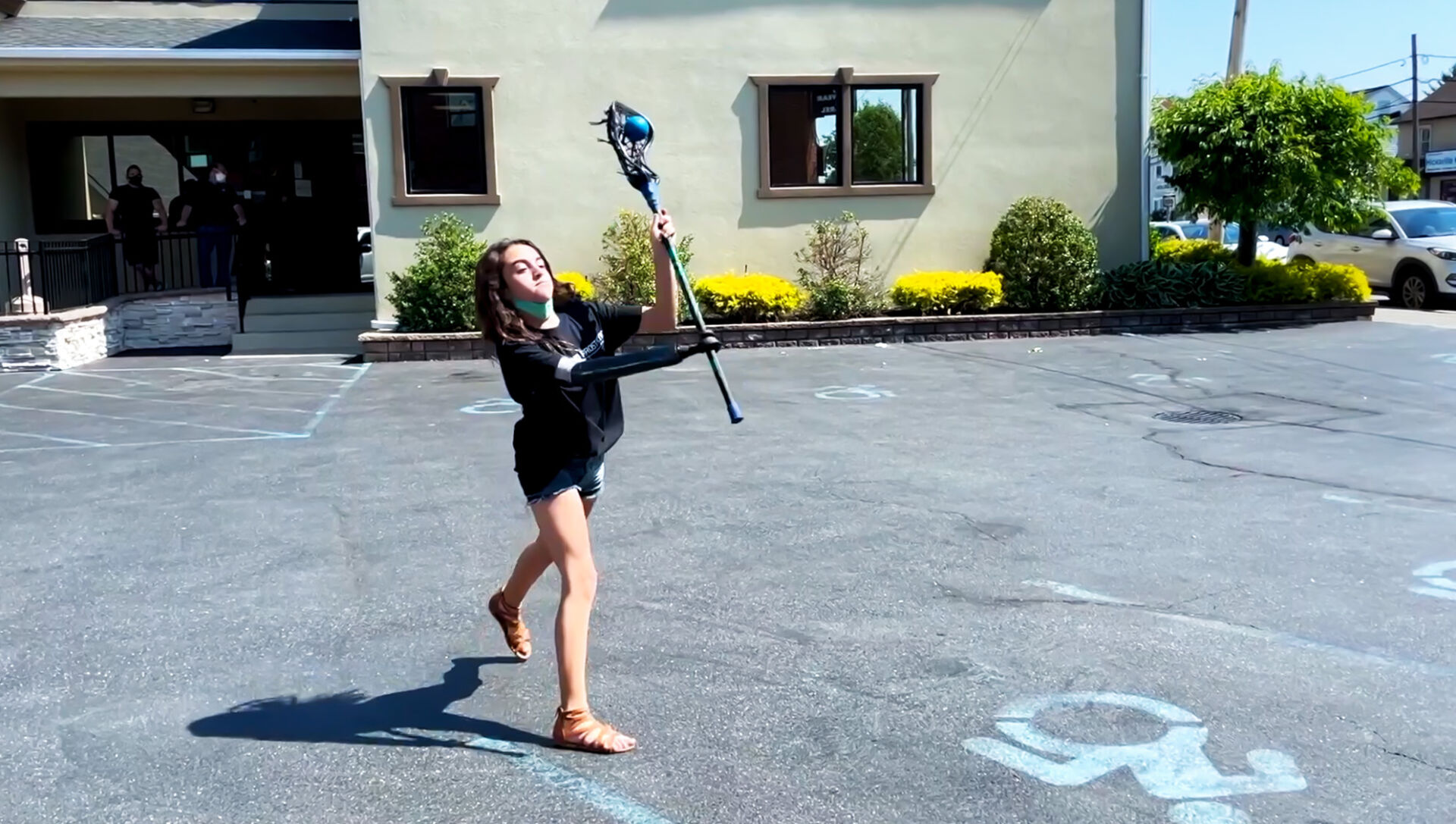 young girl playing lacrosse with prosthetic hand