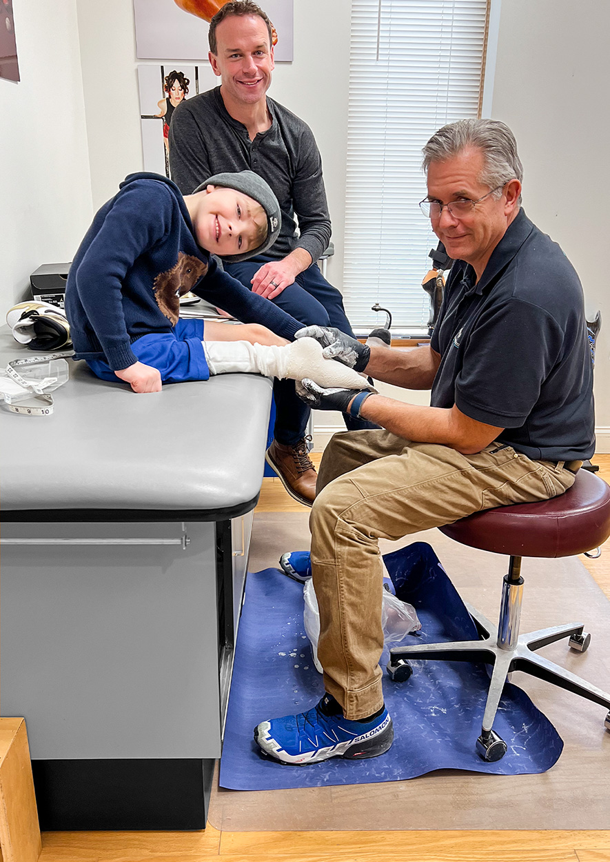 kid being casted for prosthetic by prosthetist